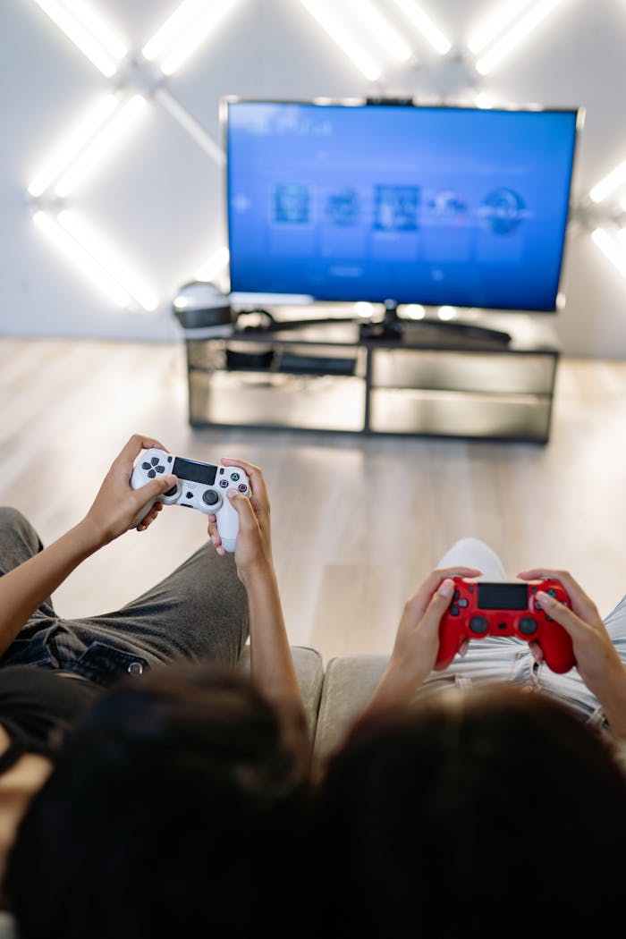 Two people enjoying video games at home with wireless controllers.
